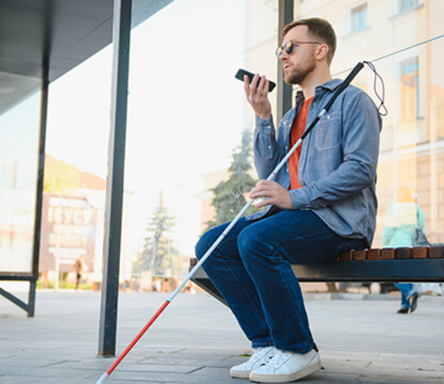 Ženska osoba u narančastoj majici drži telefon i razgovara sa nekim putem jezika za gluhonijeme